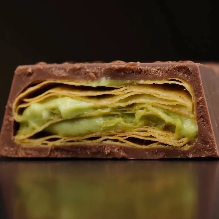 Artu Baklava im Querschnitt: Teigschichten und Pistaziencreme in Milchschokolade
